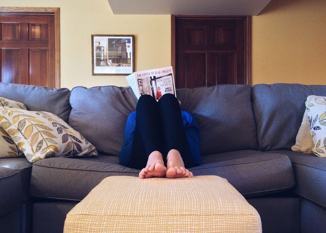 Personne détendue lisant un magazine sur un canapé