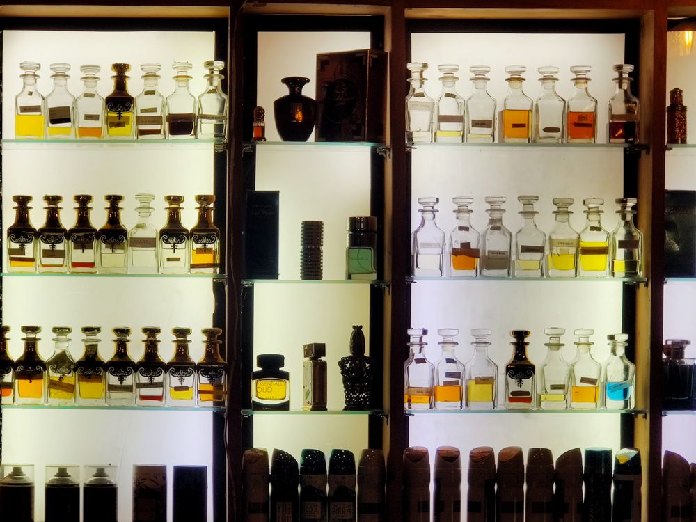 Flacons de parfums alignés sur une étagère lumineuse