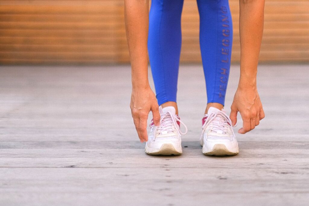 Femme en legging de sport s'étirant en salle de fitness
