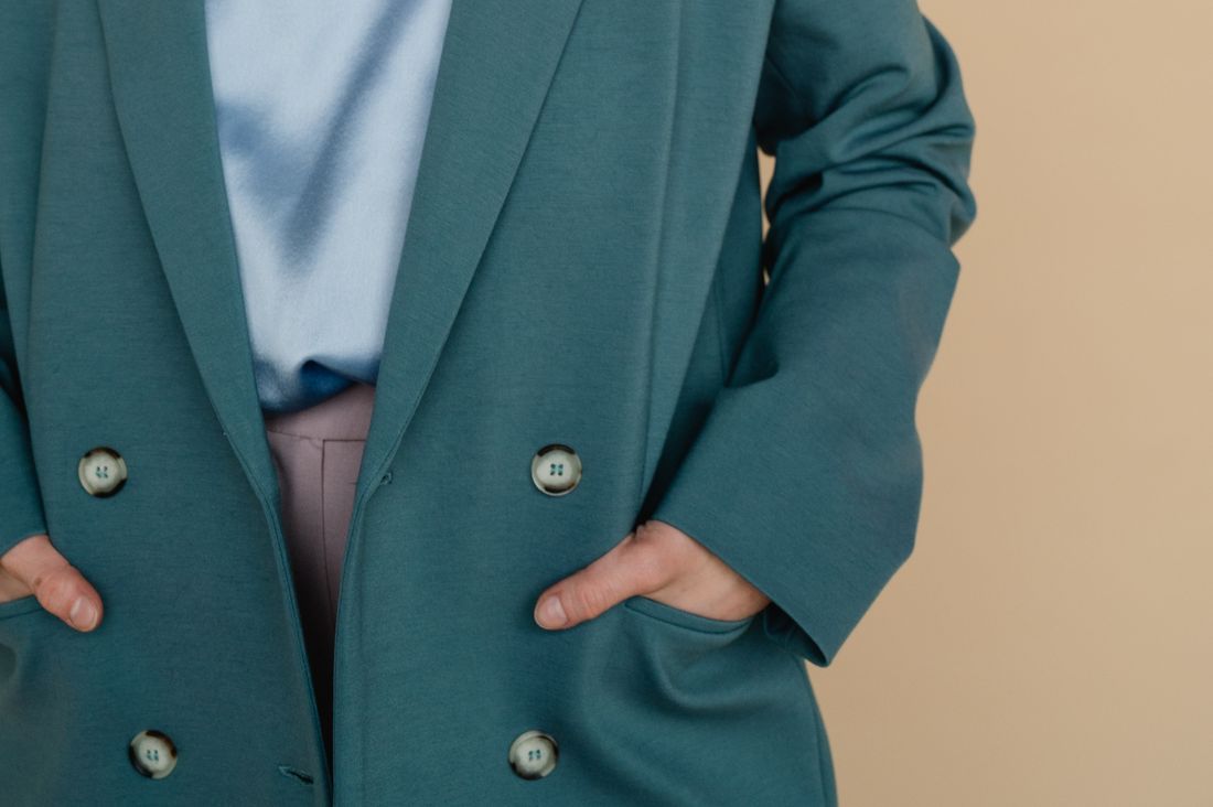 Femme les mains dans les poches d'un manteau vert tendance