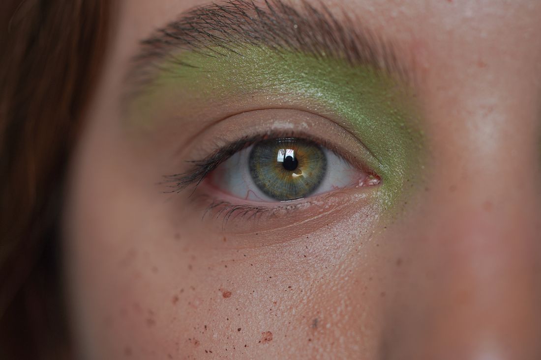 Application d'un fard à paupières vert sur l'œil