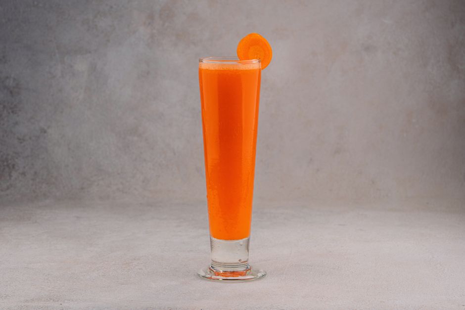 Verre de jus de carotte frais pour préparer la peau au bronzage