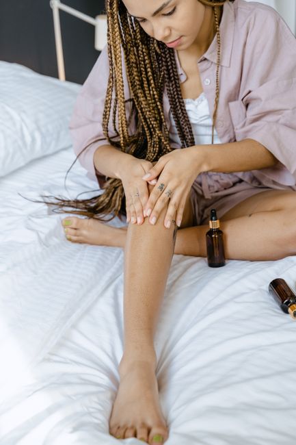 Massage d'une huile hydratante sur la jambe