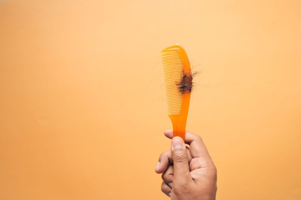 Peigne rempli de cheveux tombés, illustrant les avis négatifs sur la chute