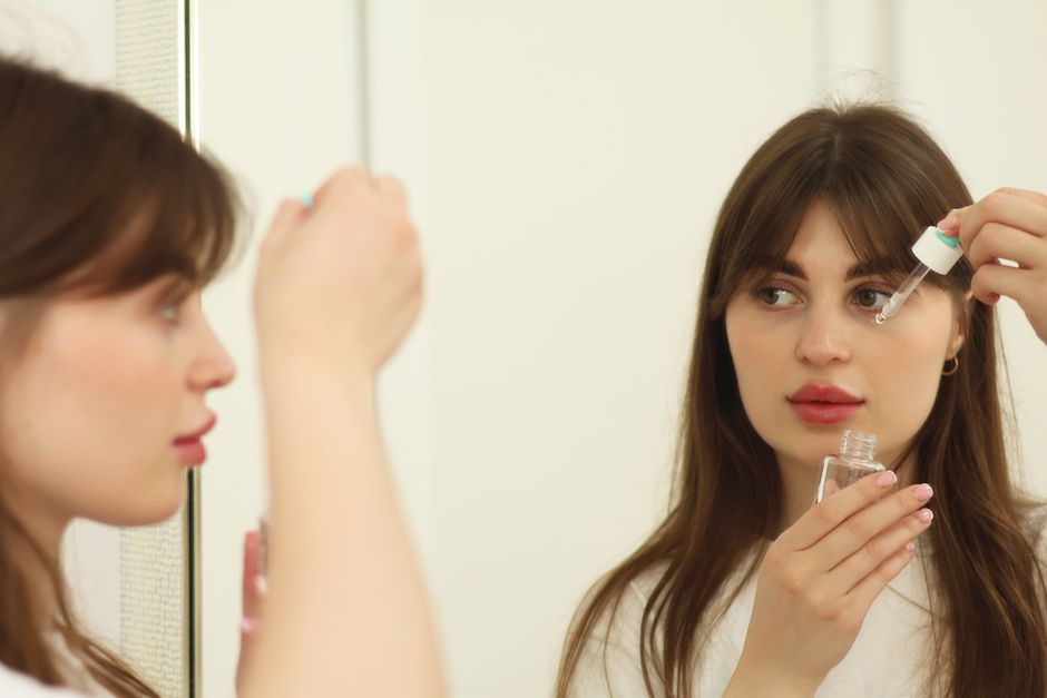 Application d'un sérum anti-rides effet immédiat devant le miroir