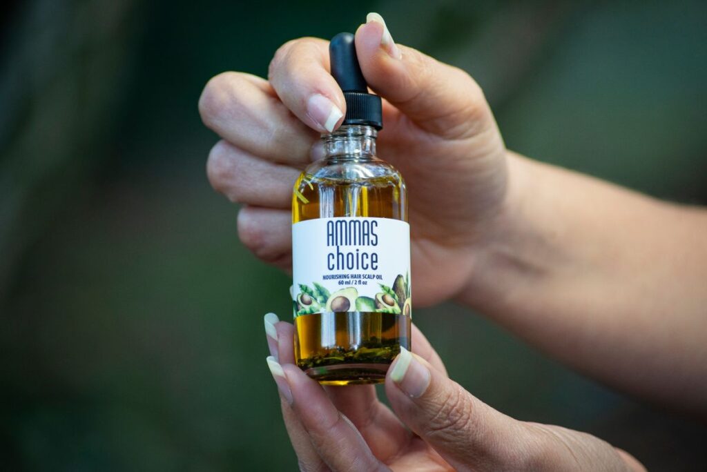 Flacon d'huile capillaire Vitalis tenu à la main