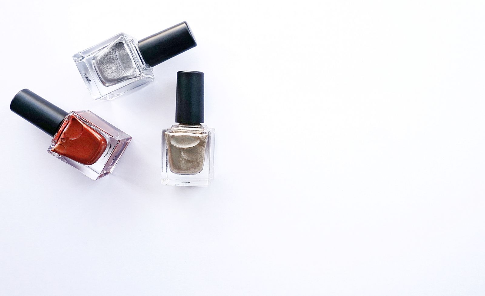 Trois flacons de vernis qui change de couleur posés sur fond blanc