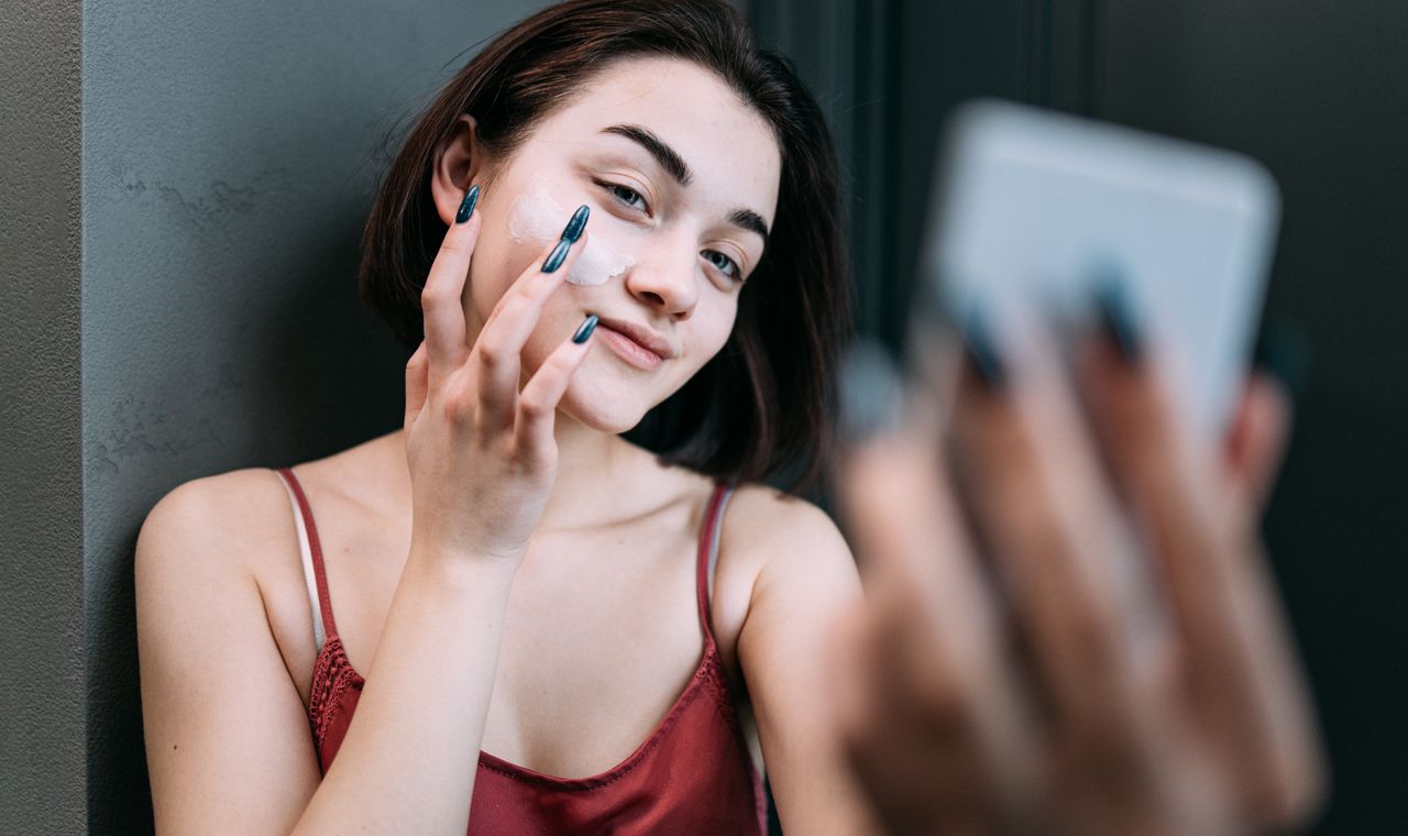 Femme appliquant une crème de jour anti-rides sur le visage